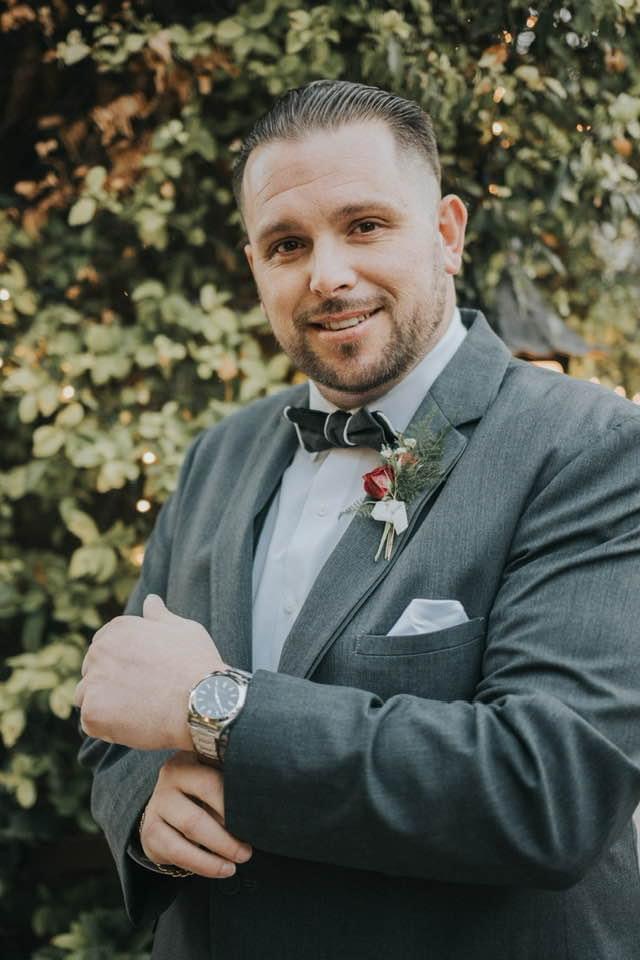 Smiling team member in a gray suit and bow tie